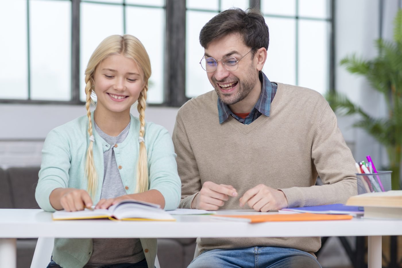 A parent and tutor reviewing a student's homework together